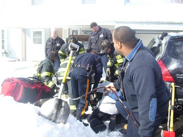 Firefighters work to remove the man's hand from the snow blower